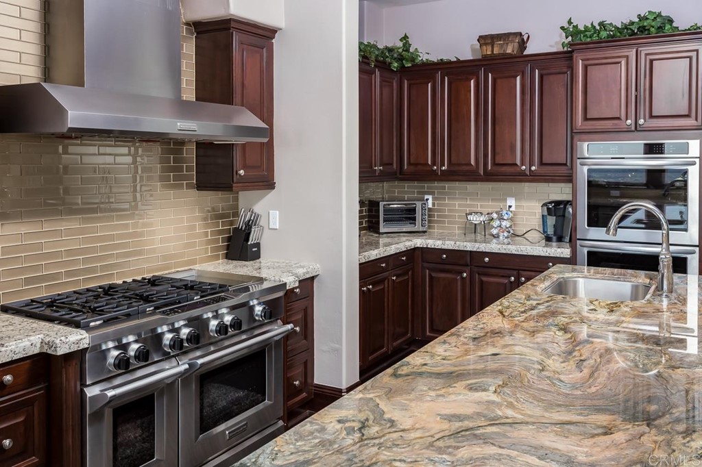 937 Pearl Drive San Marcos, CA 92078 - Photo 35 of 54 a kitchen with wooden cabinets and a stove top oven