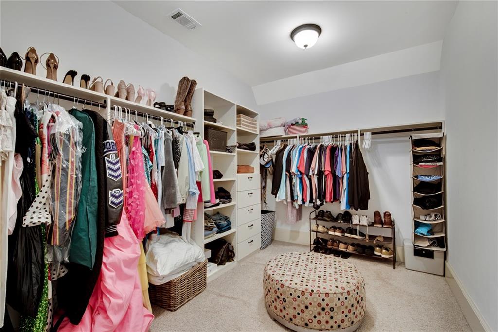 13942 Tree Loft Road Milton, GA 30004 - Photo 54 of 102 a view of walk in closet with clothes and shoes