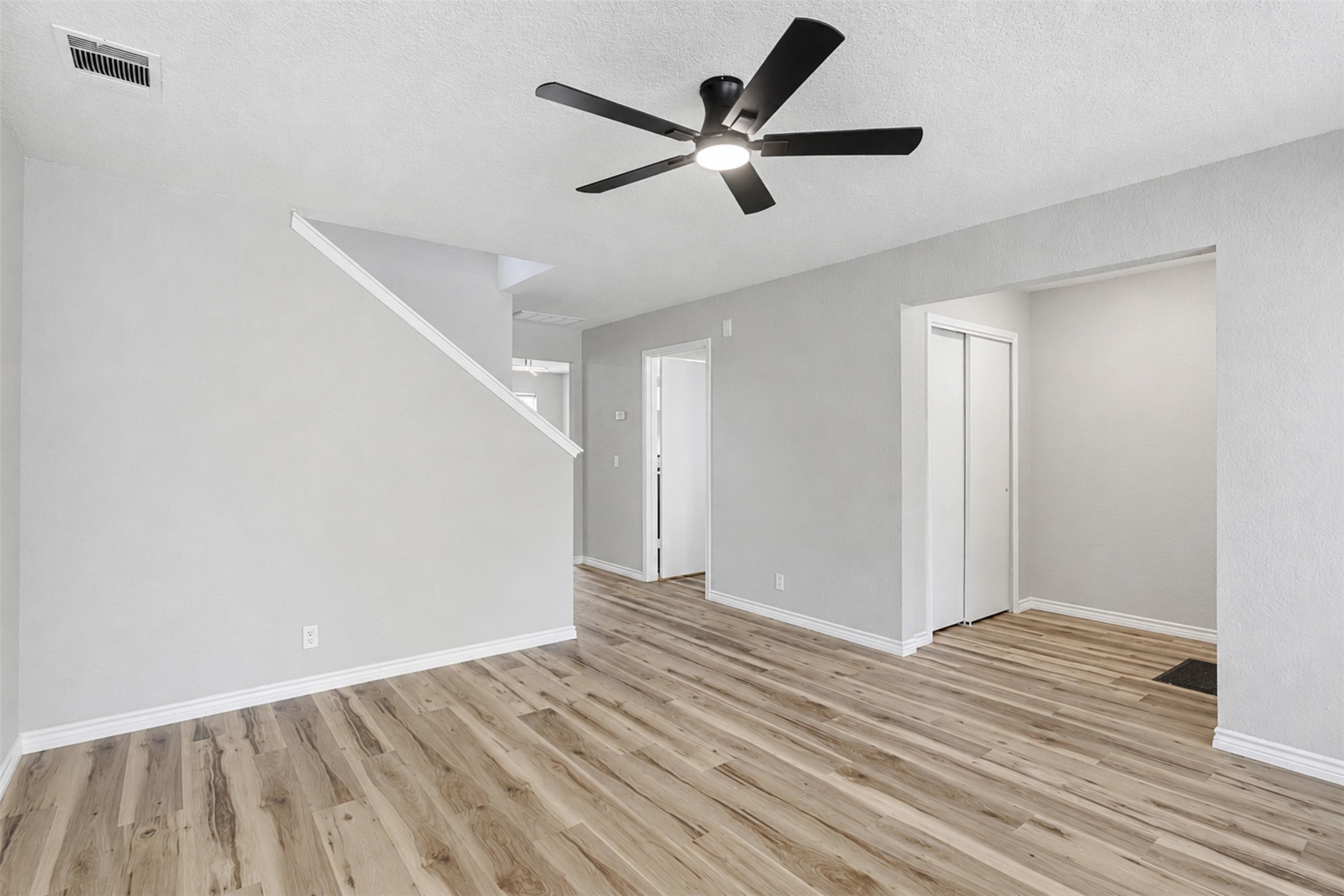 4523 Secure Lane Austin, TX 78725 - Photo 6 of 40 An open living space featuring wood flooring and a modern ceiling fan for comfortable airflow.
