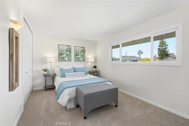 a bedroom with a bed painting on the wall and a window