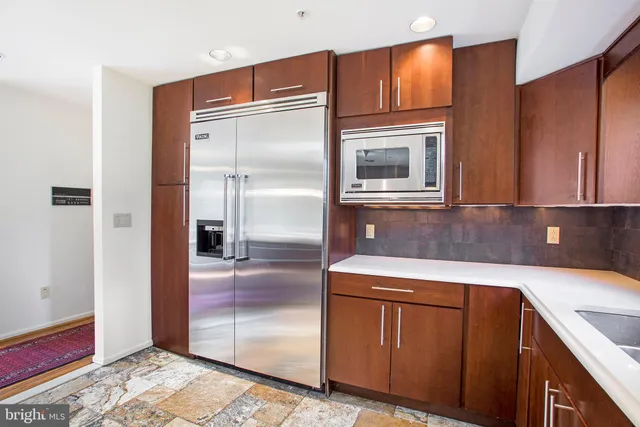 a kitchen with a sink a stove a refrigerator and wooden cabinets