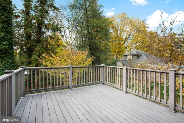 a view of an empty room with wooden floor fireplace and a window