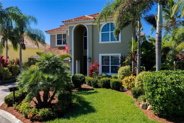 a front view of a house with a yard and potted plants