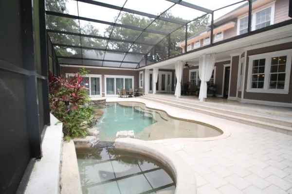a view of a swimming pool with back yard of a house
