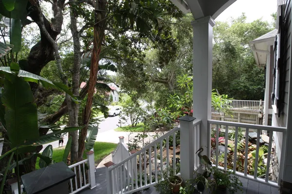 a view of a patio with lawn chairs floor to ceiling window next to an ocean