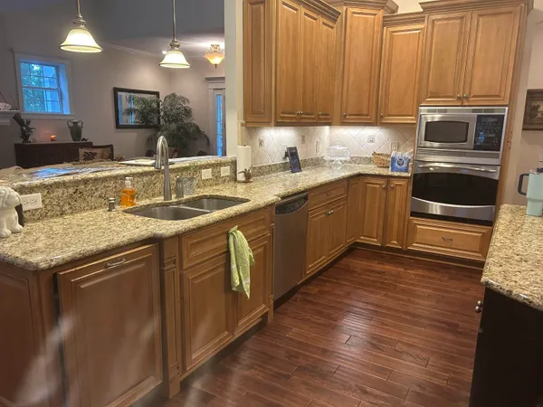 a kitchen with stainless steel appliances granite countertop a sink stove and microwave