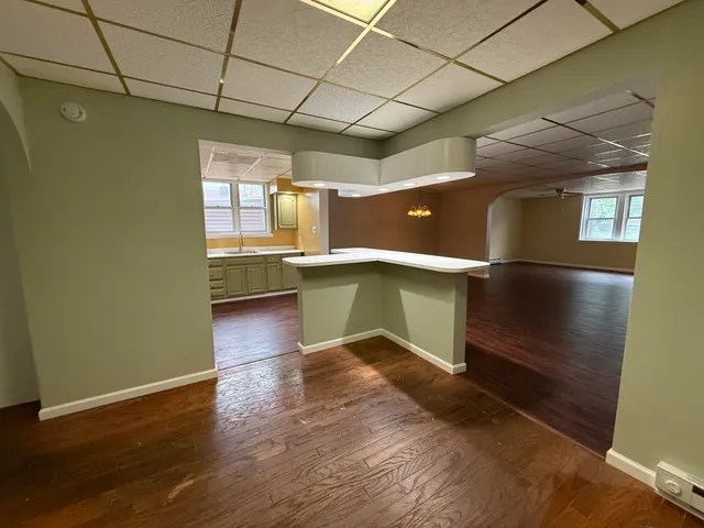 a view of a kitchen with a fridge and wooden floor