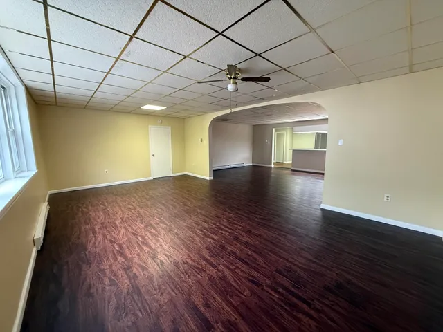 a view of empty room with wooden floor