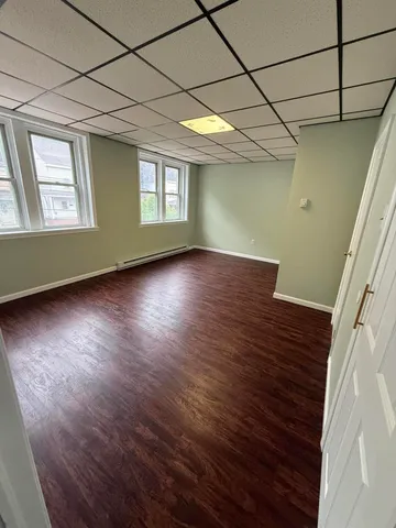 a view of a room with wooden floors and window