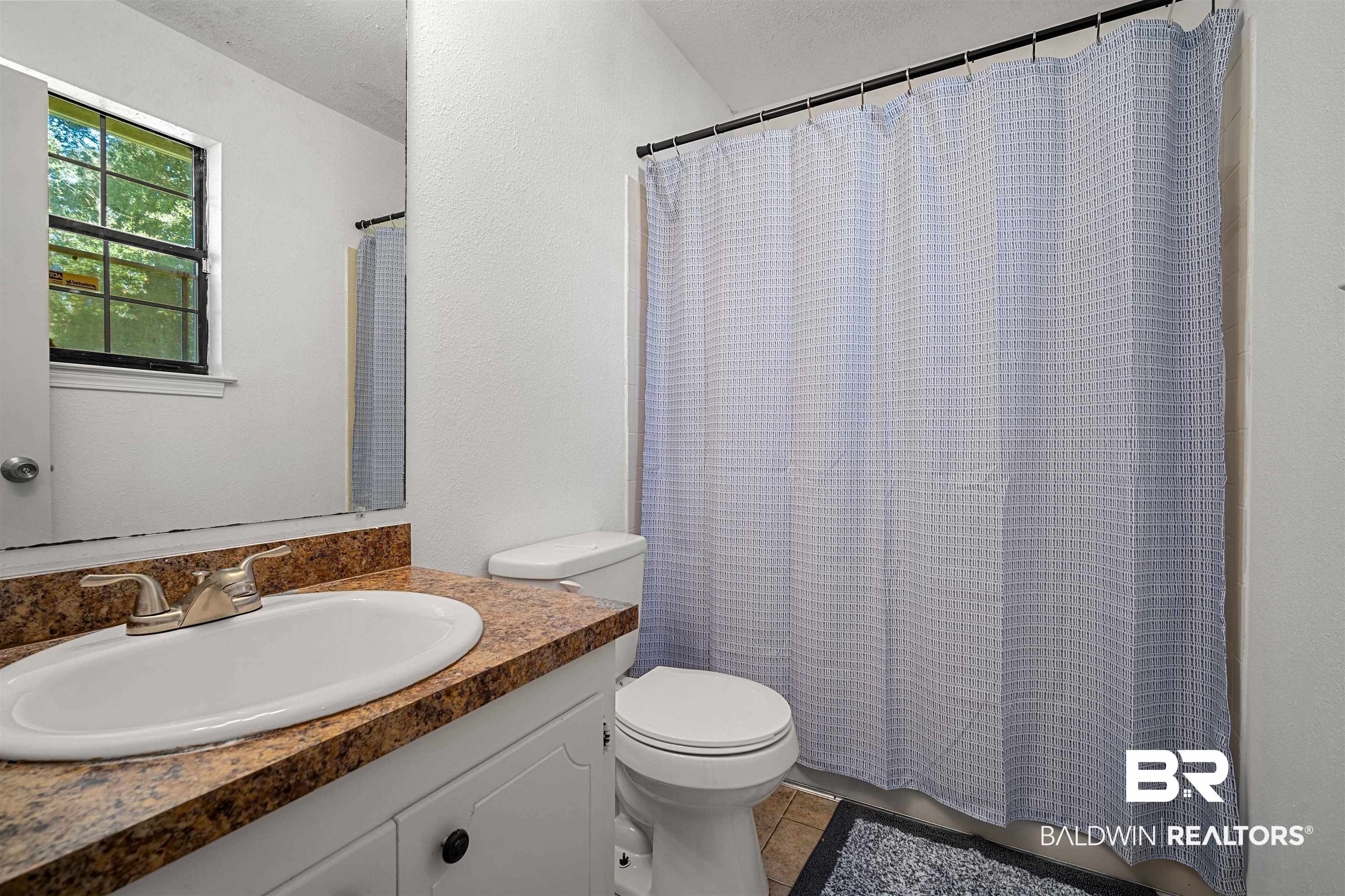12910 Del Rio Street Grand Bay, AL 36541 - Photo 16 of 26 Full bath featuring vanity, light tile patterned flooring, and a textured wall