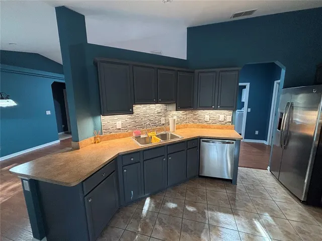 a kitchen with stainless steel appliances granite countertop a refrigerator and a sink