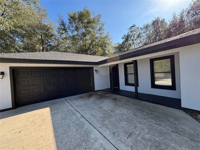 a view of backyard with large trees and wooden fence