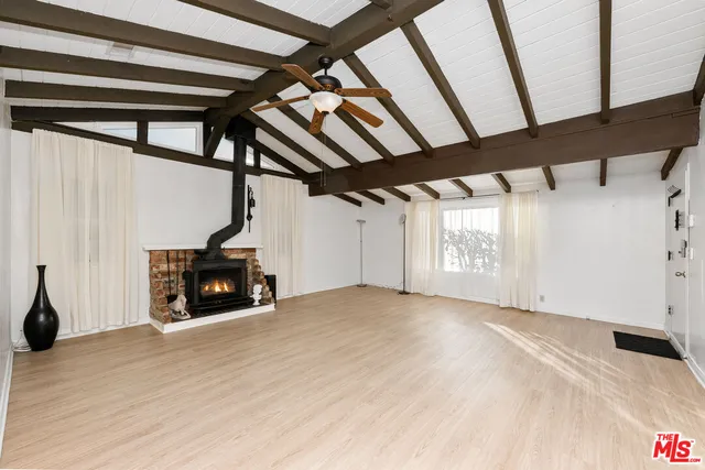 a view of an empty room with a fireplace and a window