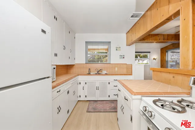 a view of a kitchen with stove and refrigerator