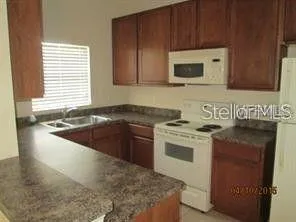a kitchen with stainless steel appliances granite countertop a stove a sink and a microwave