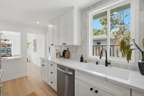 a kitchen with stainless steel appliances a sink a stove and a window