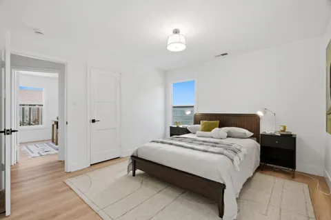 a bedroom with a bed and wooden floor