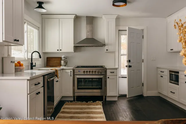 a kitchen with stainless steel appliances a stove a sink and a refrigerator
