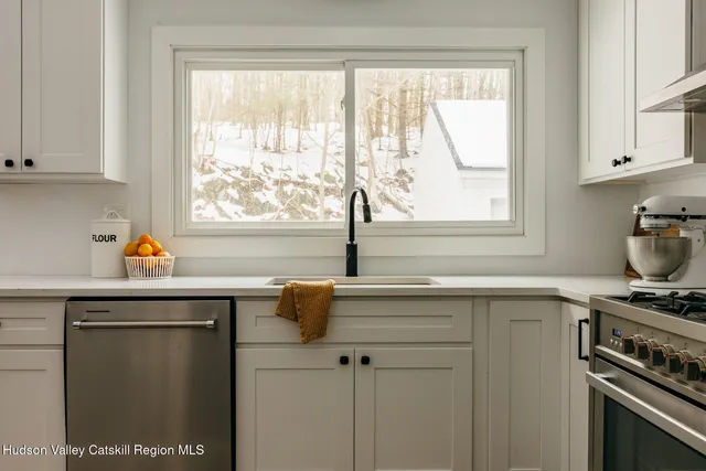 a kitchen with stainless steel appliances a sink stove and window