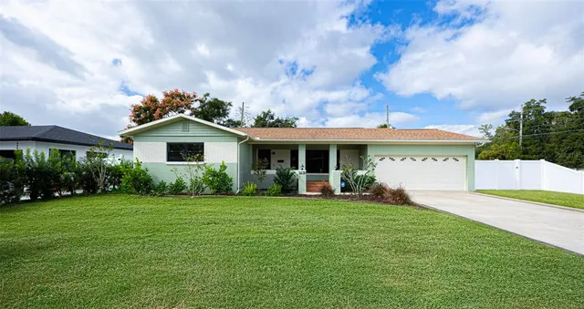 a view of a house with a yard and sitting area