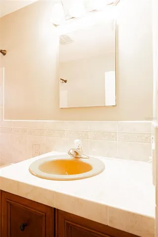 a view of empty room with wooden floor and kitchen view