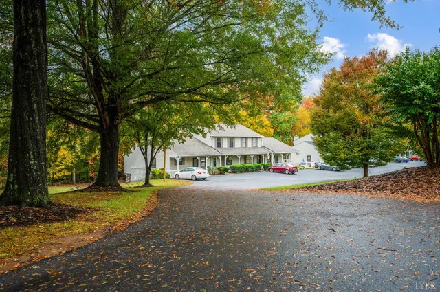 a view of a house with a yard and large tree