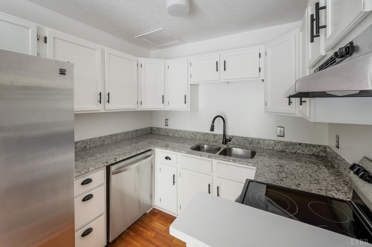 102 Goose Ridge Drive Forest, VA 24551 - Photo 21 of 57 a kitchen with granite countertop a sink stove and white cabinets