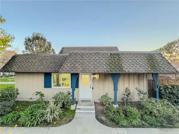 a view of a house with a plants and wooden fence