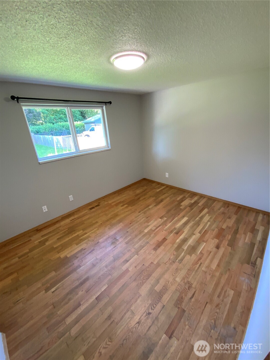 621 Brookdale Road East Tacoma, WA 98445 - Photo 13 of 14 an empty room with wooden floor and windows