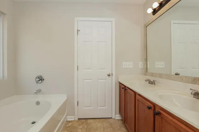 a bathroom with a tub sink and mirror