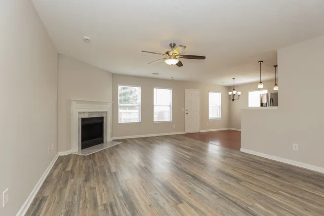 a view of an empty room with a fireplace and a window