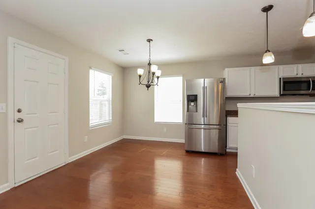a kitchen with stainless steel appliances a refrigerator and a chandelier