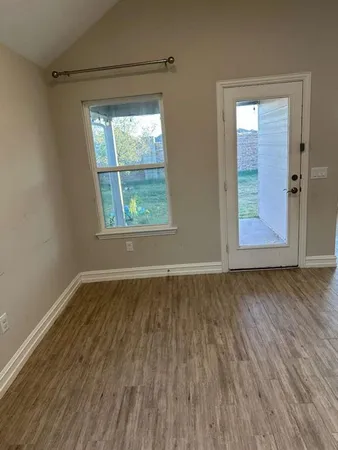a kitchen with granite countertop a stove top oven a sink a counter space and wooden floor