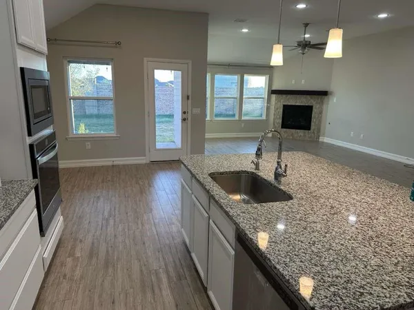 a kitchen with stainless steel appliances granite countertop a sink a stove and a refrigerator