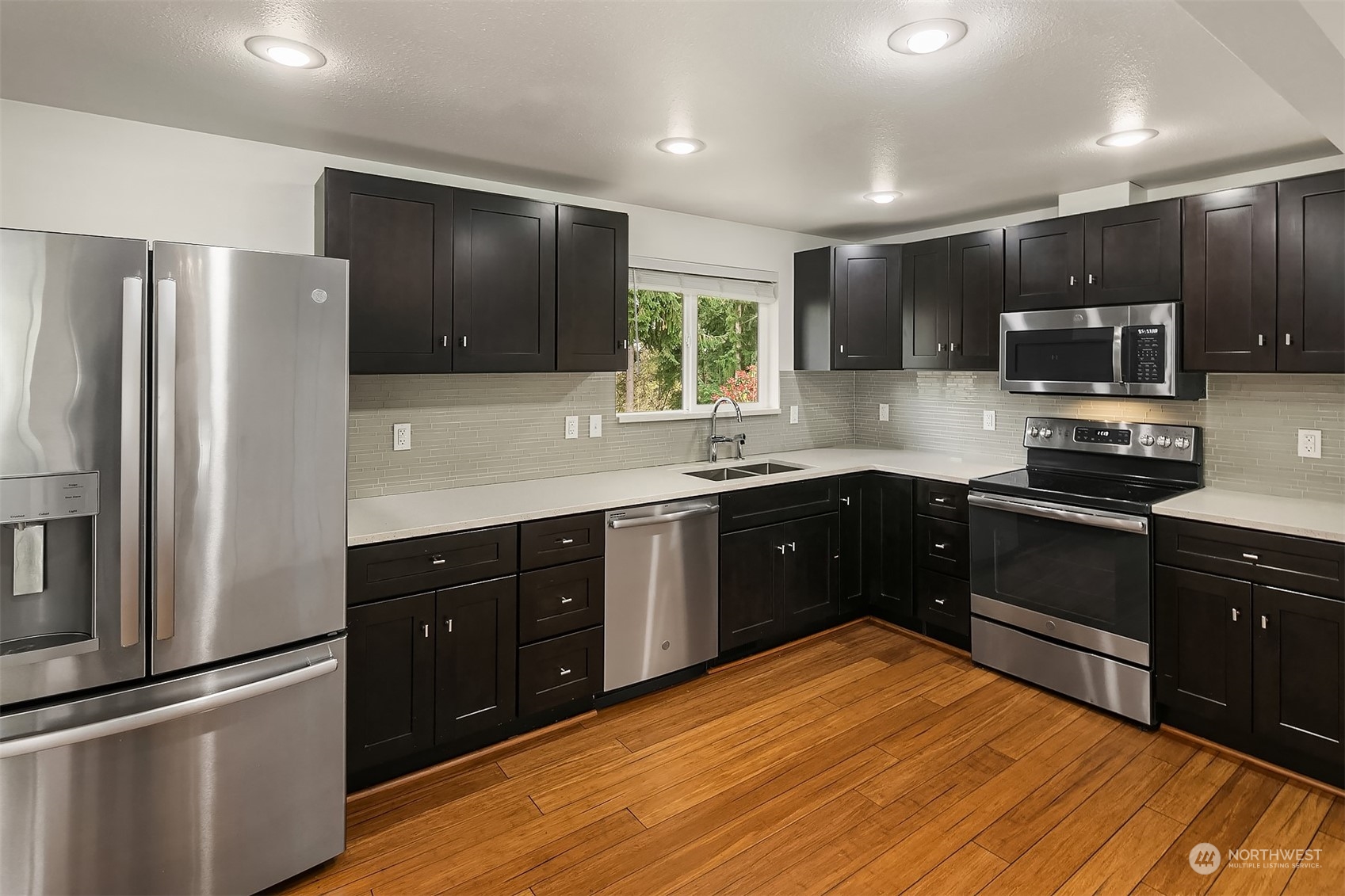 4419 Southeast 4th Place Renton, WA 98059 - Photo 11 of 21 a kitchen with stainless steel appliances kitchen island granite countertop a refrigerator stove top oven and sink