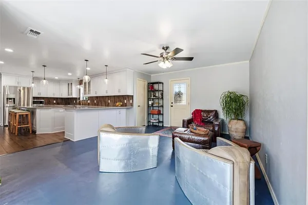 a living room with kitchen island furniture and a chandelier