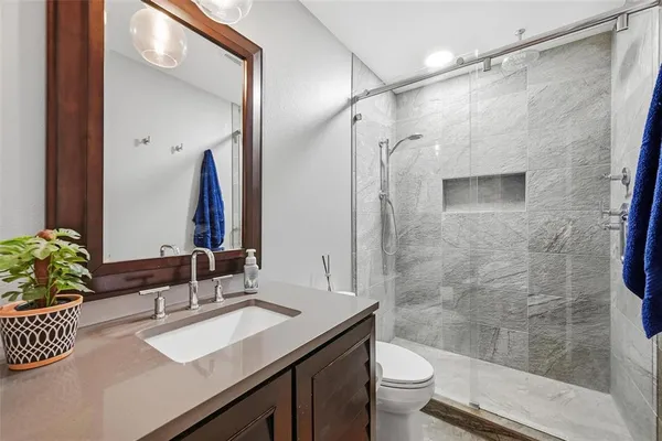 a bathroom with a sink a toilet and a large mirror