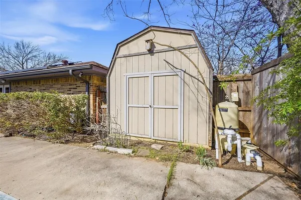 a view of a house with a large tree and wooden fence