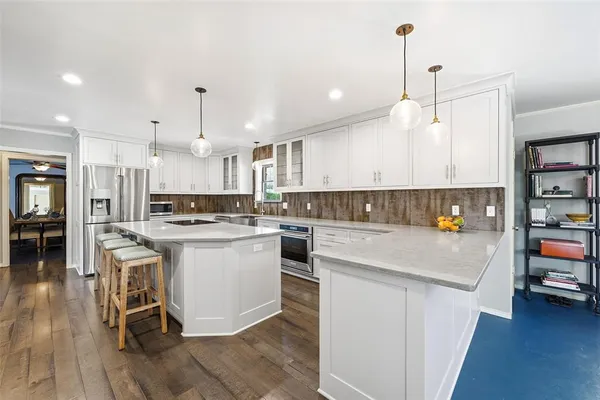 a kitchen with stainless steel appliances a stove a sink a refrigerator and cabinets