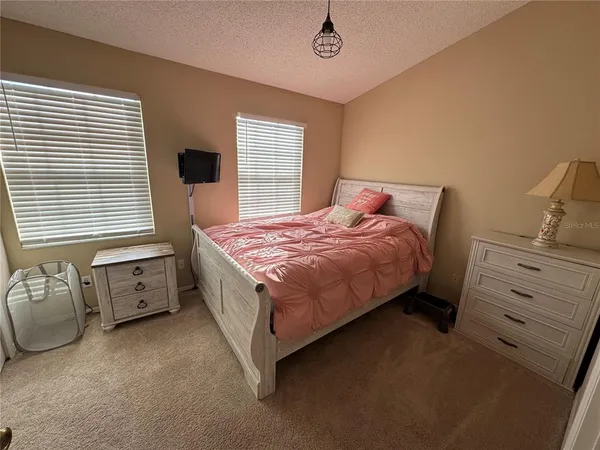 a spacious bedroom with a bed and a window