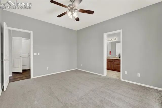 a view of an empty room and chandelier fan