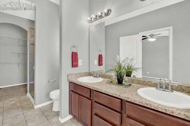 a bathroom with a granite countertop sink a toilet and a mirror