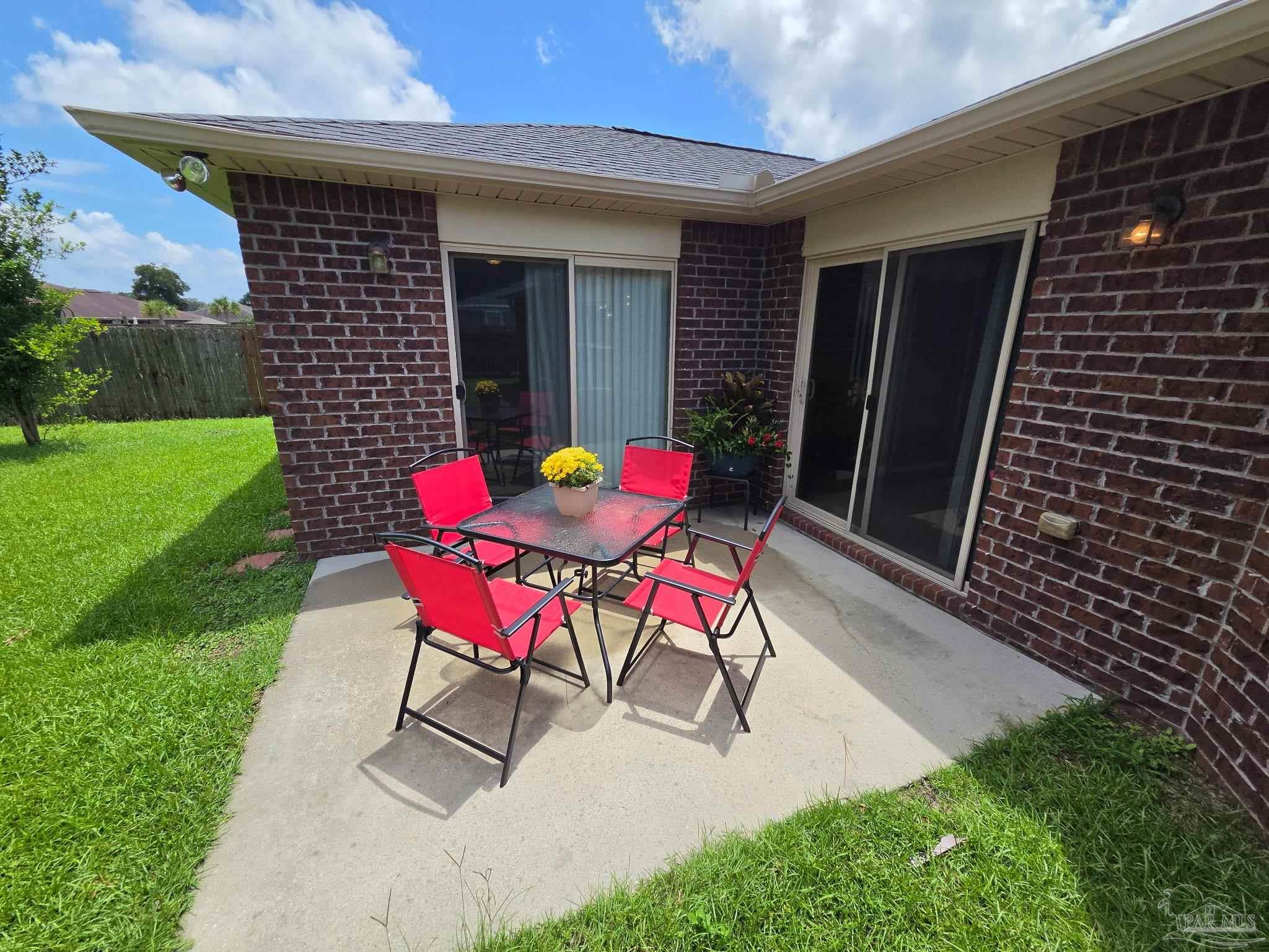 5709 Mill Stream Way Pace, FL 32571 - Photo 2 of 48 a patio with table and chairs