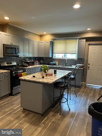 a kitchen with stainless steel appliances granite countertop a sink a stove and refrigerator