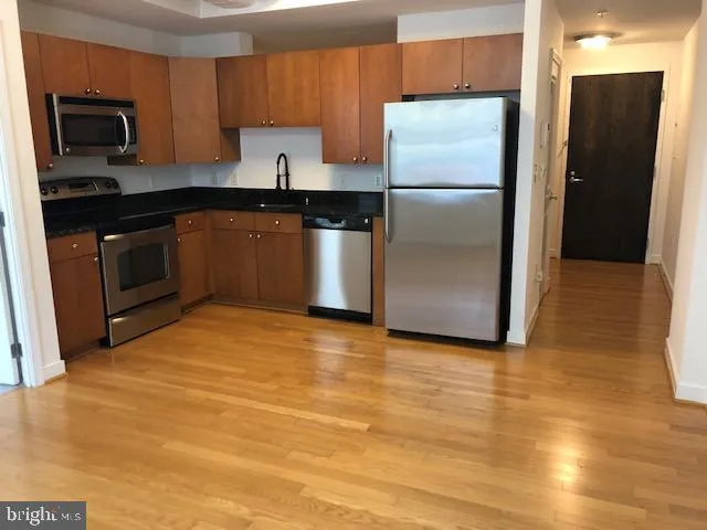 a kitchen with granite countertop a refrigerator stove and microwave