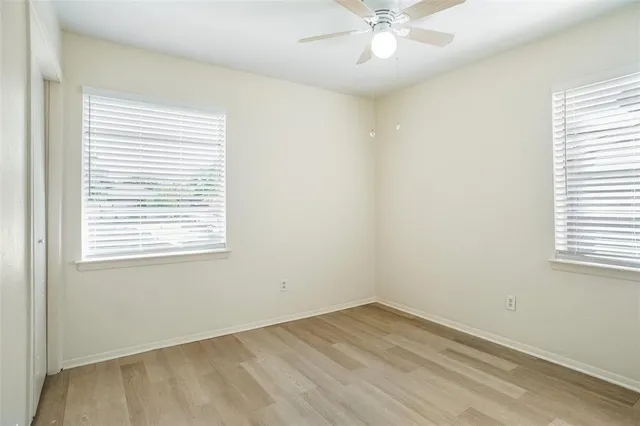 an empty room with a window and wooden floor