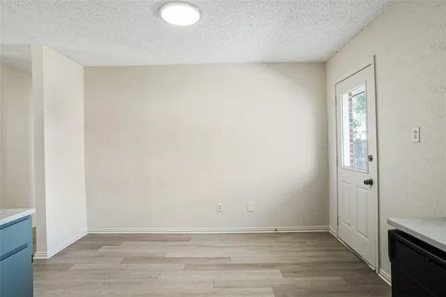an empty room with wooden floor and sliding door