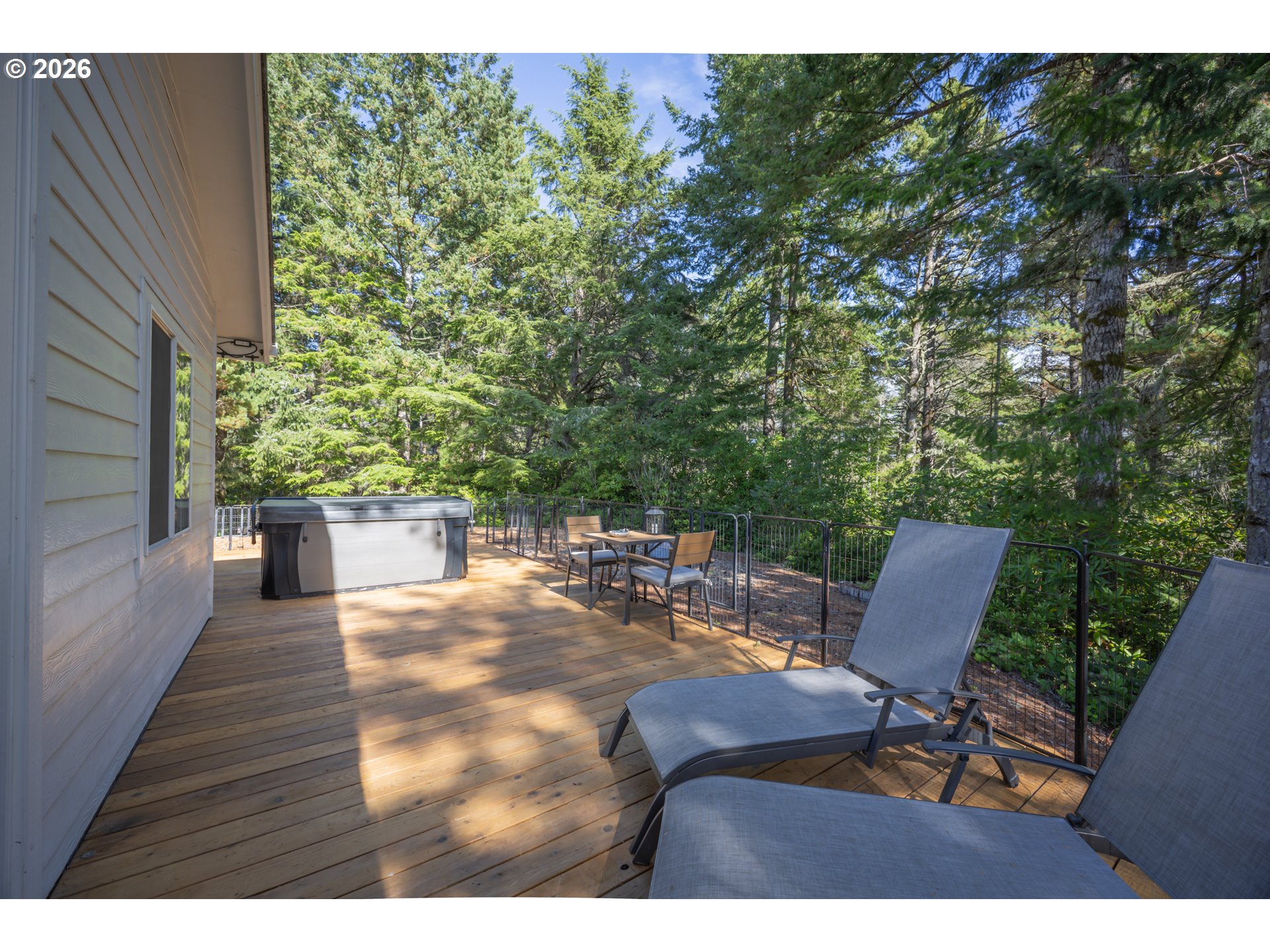 2193 13th Street Florence, OR 97439 - Photo 31 of 48 a view of a patio with table and chairs with wooden floor and fence