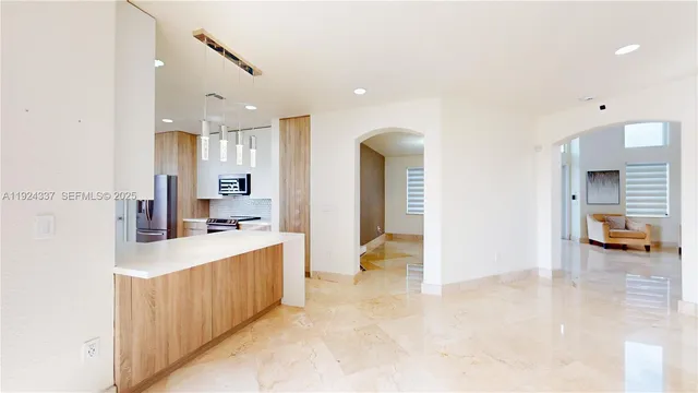 a large room with kitchen island a large window in it