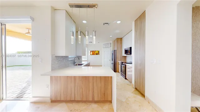 a large kitchen with stainless steel appliances granite countertop a lot of counter space and a sink
